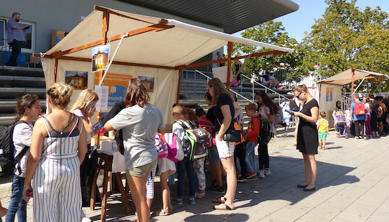 Eine Gruppe Kinder und Erwachsener an einem Stand.